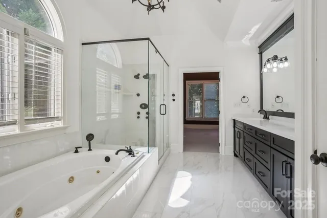 a spacious bathroom with a tub sink shower and mirror