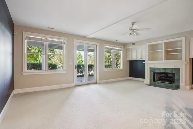 a view of an empty room with window and fire place