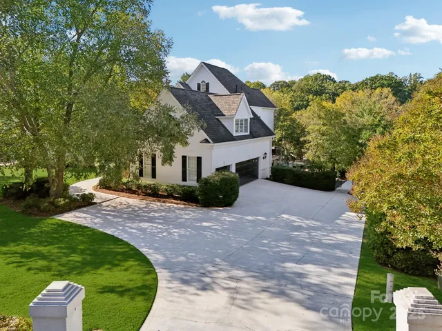 a front view of a house with a yard and trees