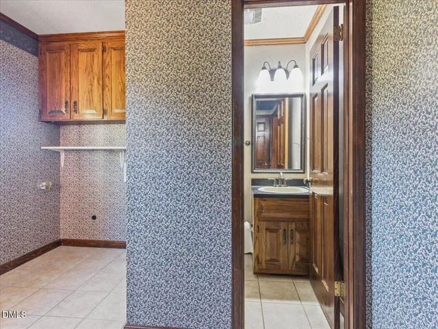 a bathroom with a sink and a large mirror next to a window