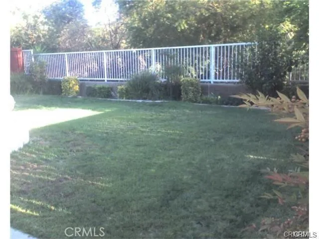 a view of a backyard with iron fence