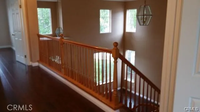 a view of a hallway with wooden floor and stairs