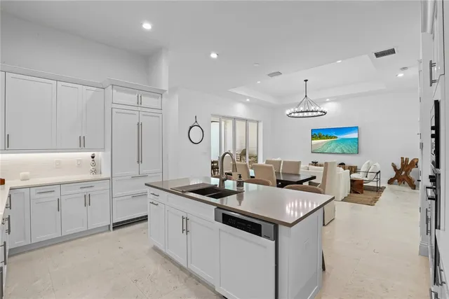 a kitchen that has a sink and a stove with white countertops