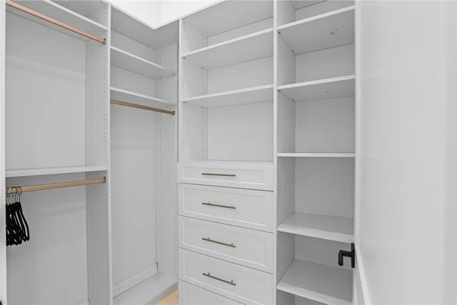 a view of walk in closet with empty racks