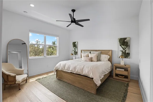 a bedroom with a bed wooden floor and window