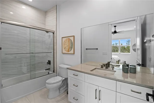 a bathroom with a granite countertop sink a toilet and shower