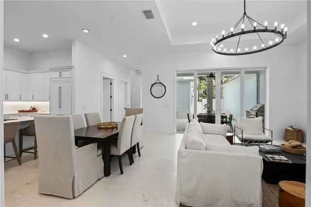 a living room with furniture chandelier and kitchen view