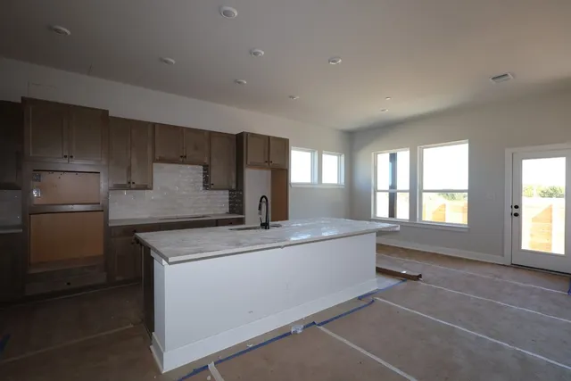 a kitchen with stainless steel appliances granite countertop a sink and a refrigerator