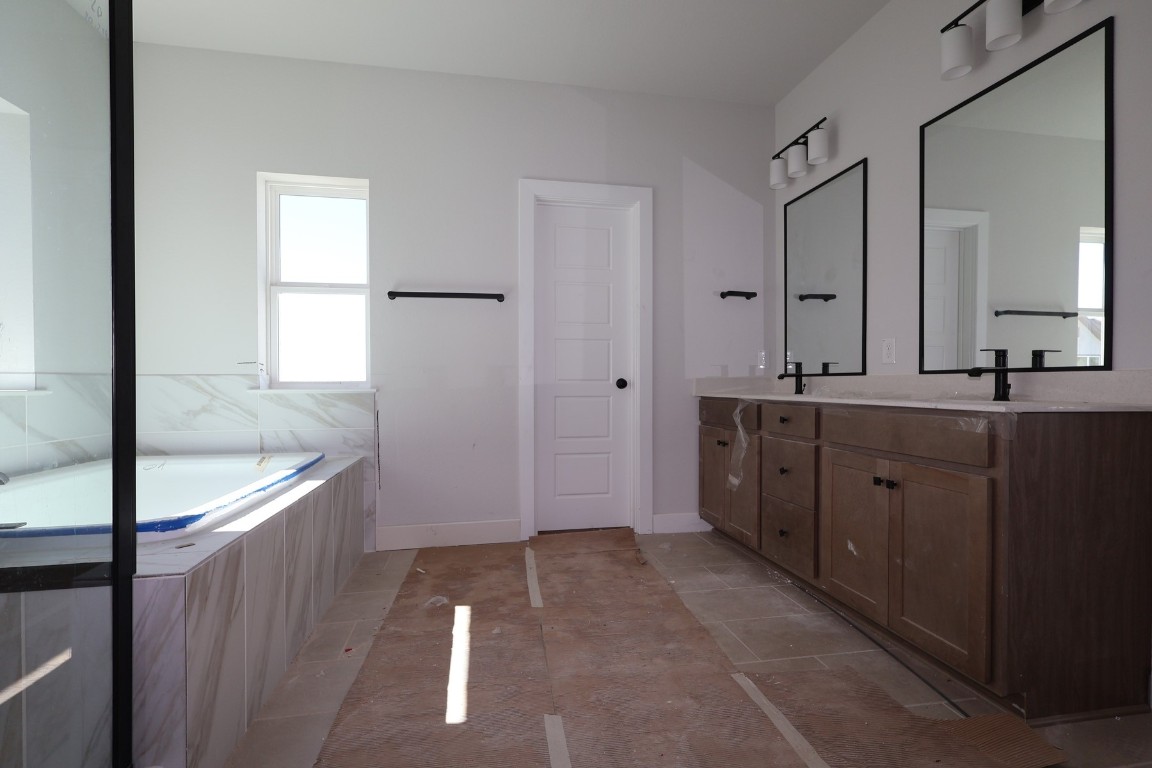 805 Nadal Path Round Rock, TX 78664 - Photo 4 of 17 a spacious bathroom with a granite countertop sink a toilet a mirror and shower