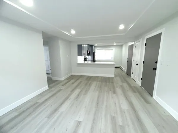 a view of empty room with wooden floor and window