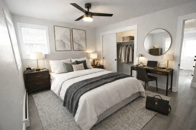 a bedroom with a bed a mirror and a large window