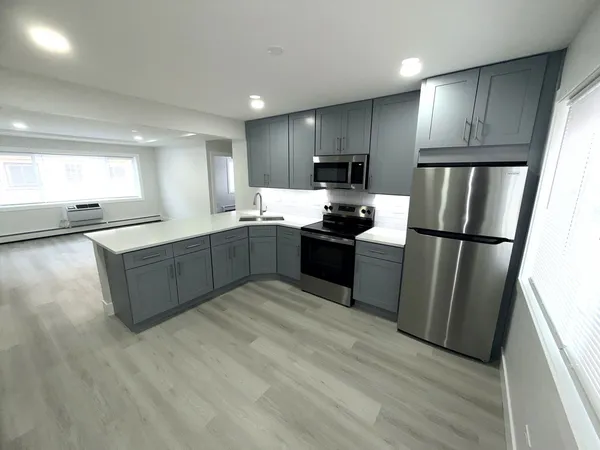 a kitchen with stainless steel appliances granite countertop a refrigerator a sink a stove a microwave a sink a refrigerator and cabinets