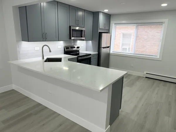a kitchen with kitchen island a sink appliances and cabinets