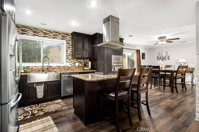 a kitchen with stainless steel appliances granite countertop a sink and a refrigerator