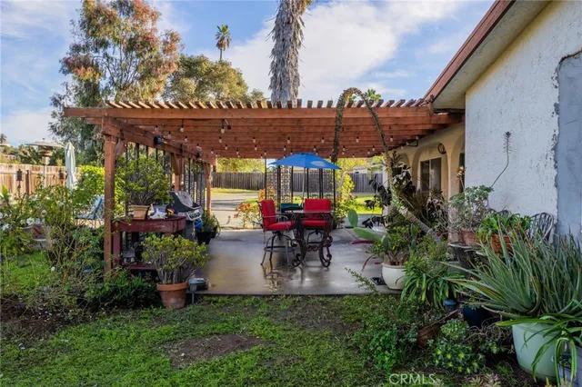 a view of a patio with table and chairs potted plants and palm tree