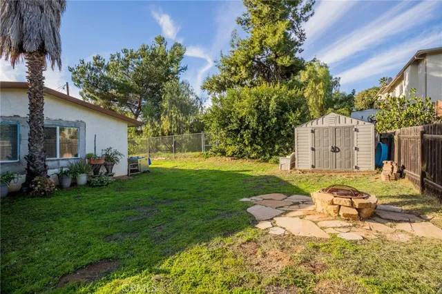 a view of a house with backyard and sitting area
