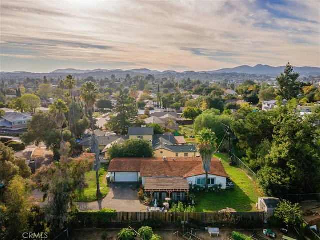 an aerial view of residential houses with outdoor space and trees