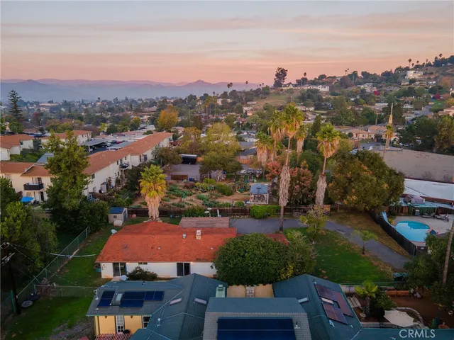an aerial view of residential houses with outdoor space and trees
