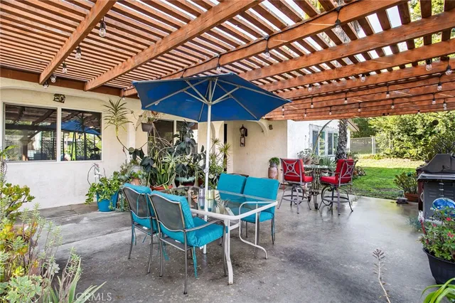 a view of a patio with table and chairs under an umbrella