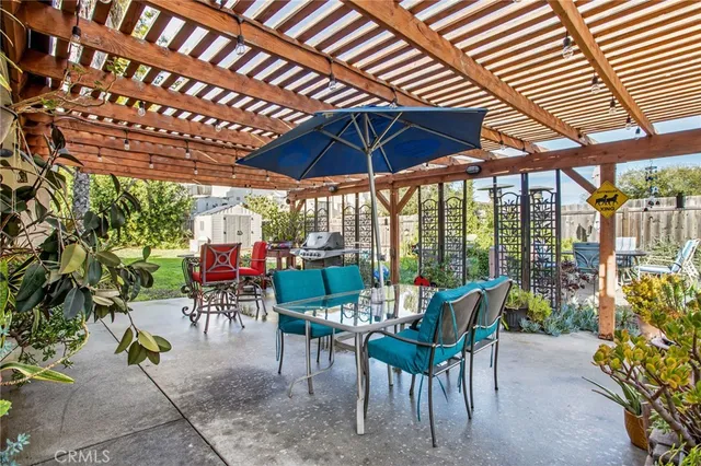 a view of a patio with a table and chairs under an umbrella
