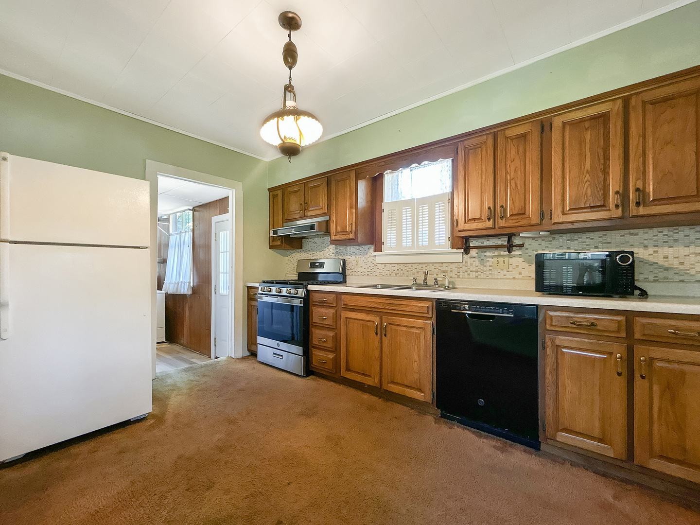 20 South Church Street Princeton, IL 61356 - Photo 5 of 17 a kitchen with stainless steel appliances granite countertop a refrigerator a sink dishwasher a stove top oven a kitchen island and chairs with wooden floor