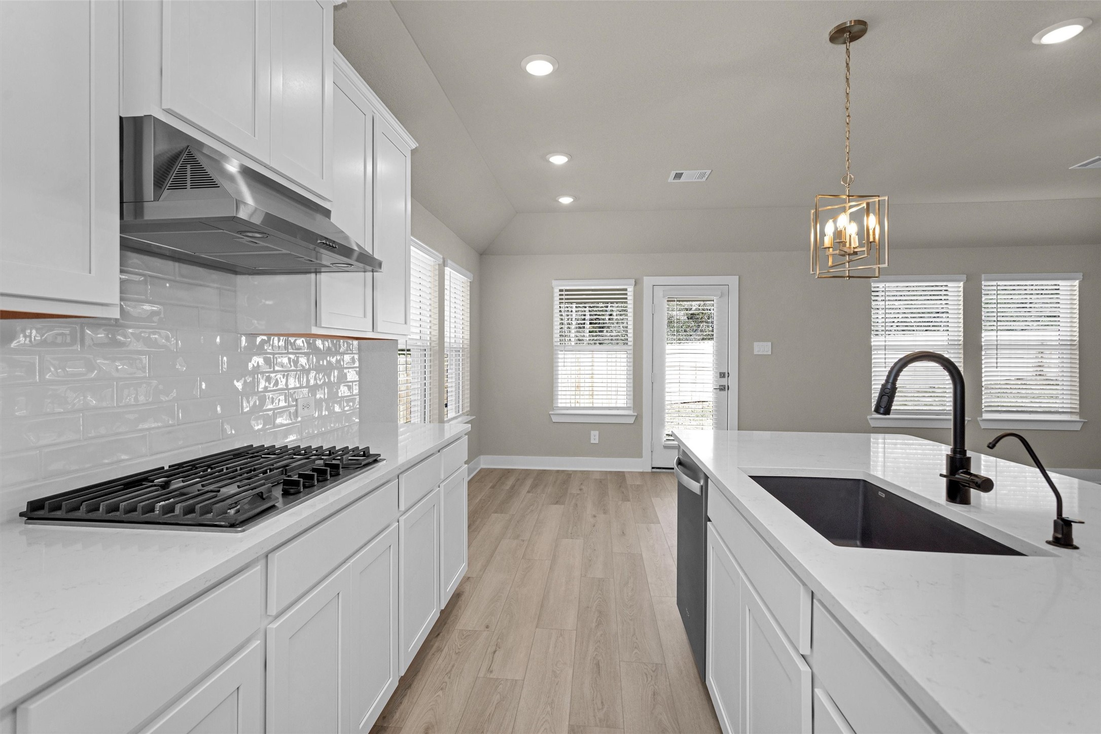 2002 Bluff Oak Street Conroe, TX 77304 - Photo 20 of 30 a kitchen with kitchen island stainless steel appliances a sink a stove and a wooden floors