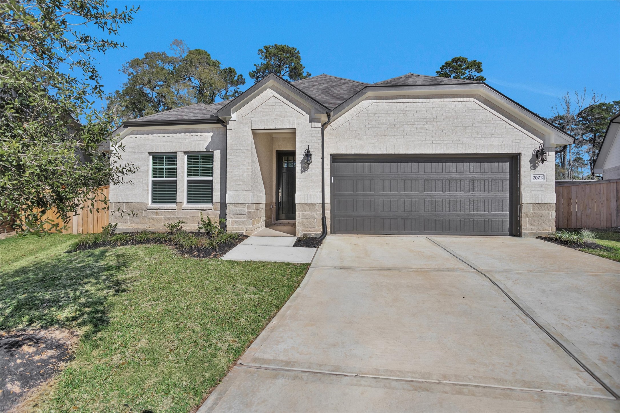 2002 Bluff Oak Street Conroe, TX 77304 - Photo 2 of 30 a front view of a house with a yard and garage
