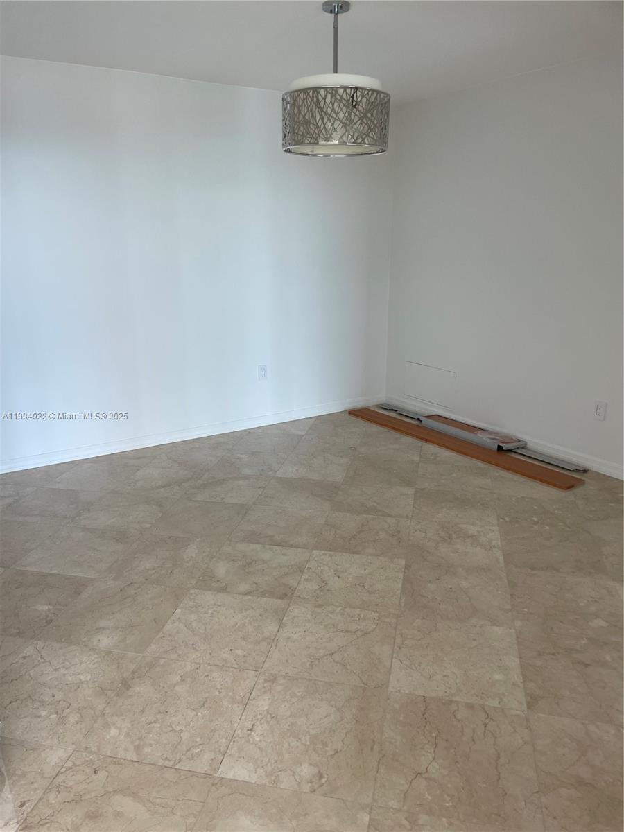 16500 Collins Avenue, Unit 1455 Sunny Isles Beach, FL 33160 - Photo 14 of 35 a view of an empty room with a chandelier fan