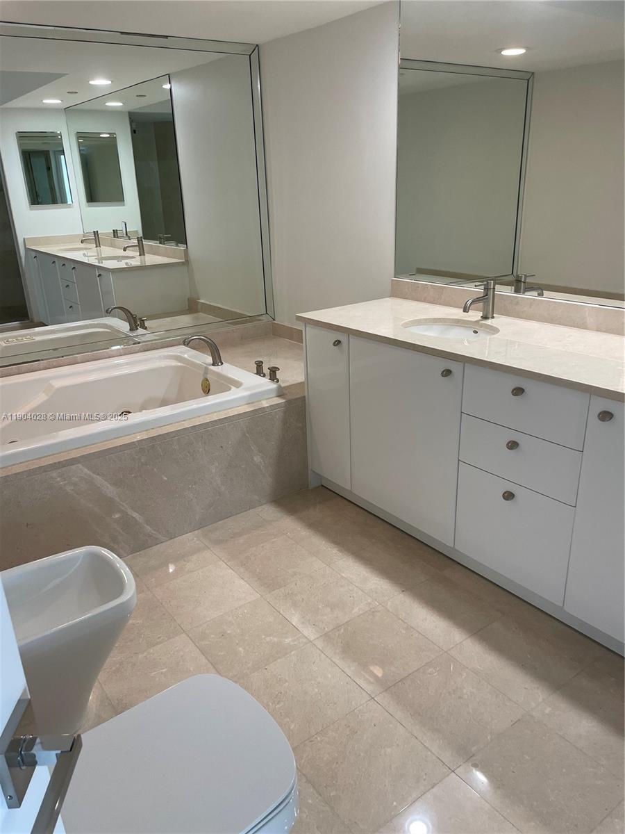 16500 Collins Avenue, Unit 1455 Sunny Isles Beach, FL 33160 - Photo 21 of 35 a bathroom with a bathtub sink mirror and toilet