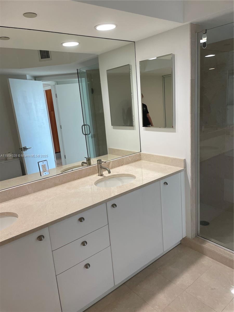 16500 Collins Avenue, Unit 1455 Sunny Isles Beach, FL 33160 - Photo 22 of 35 a bathroom with a double vanity sink and mirror