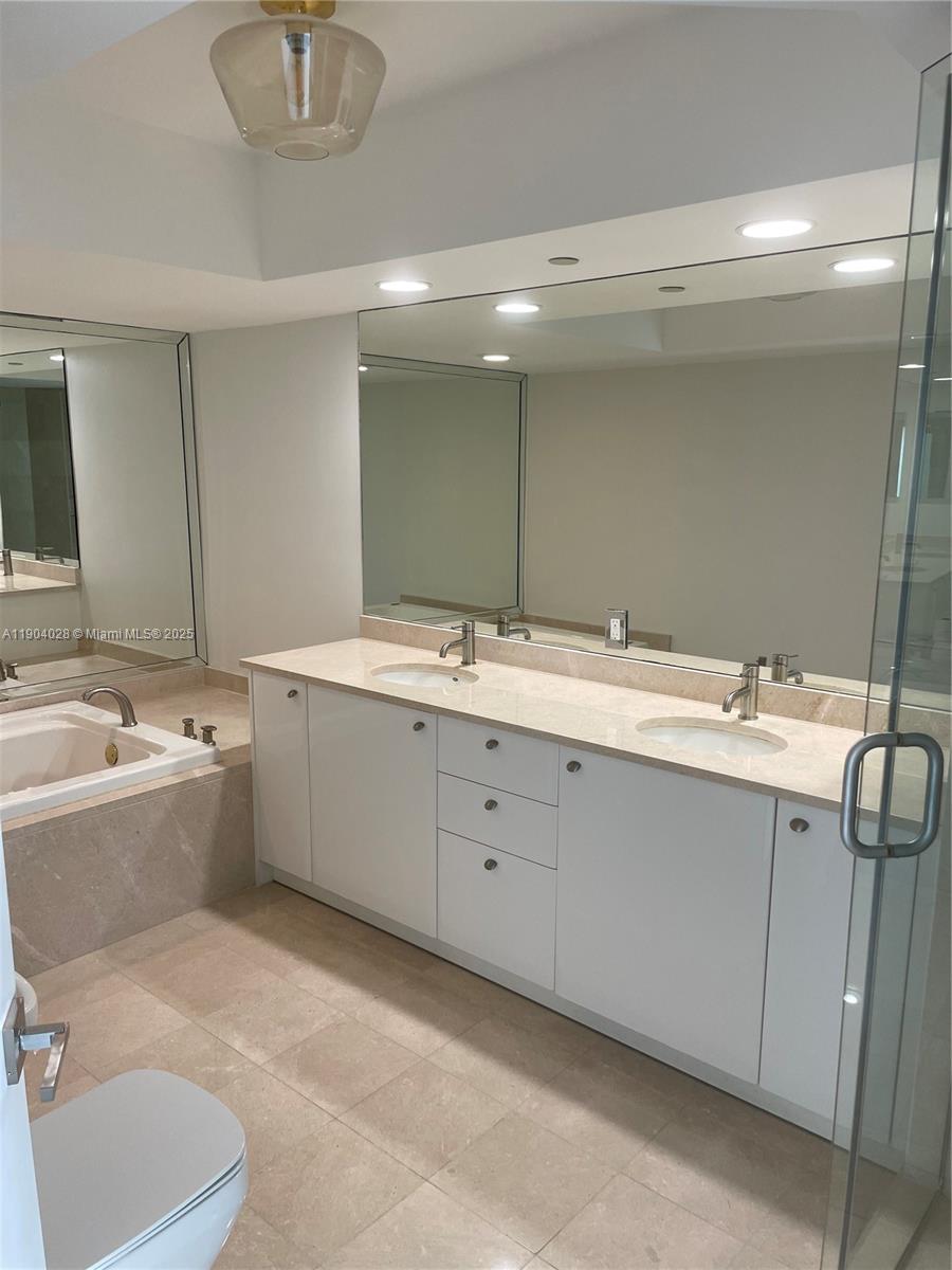 16500 Collins Avenue, Unit 1455 Sunny Isles Beach, FL 33160 - Photo 23 of 35 a bathroom with a tub sink and mirror