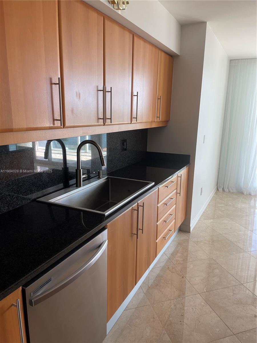 16500 Collins Avenue, Unit 1455 Sunny Isles Beach, FL 33160 - Photo 10 of 35 a kitchen with granite countertop a sink and cabinets
