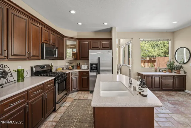 a kitchen with kitchen island granite countertop a sink stove and refrigerator