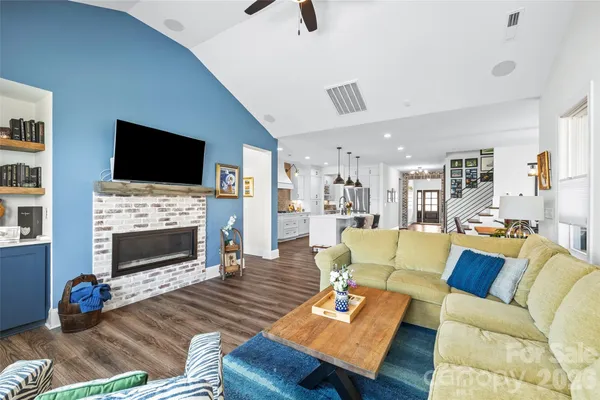 a living room with furniture a fireplace and a flat screen tv