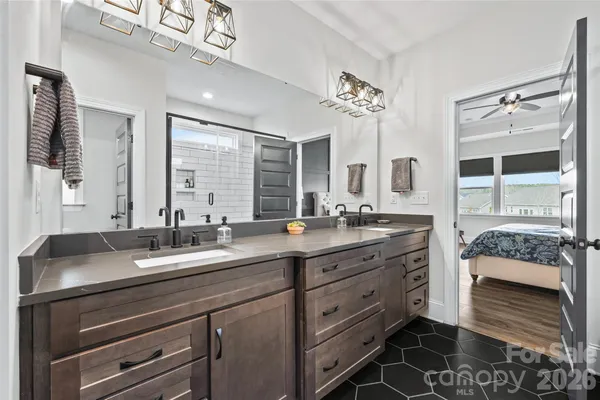 a bathroom with double vanity and a mirror