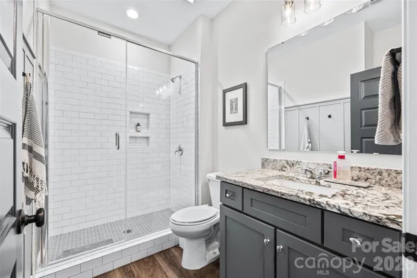 a bathroom with a granite countertop sink toilet and shower