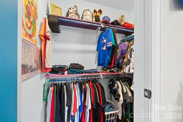 a view of walk in closet with clothes and shoes
