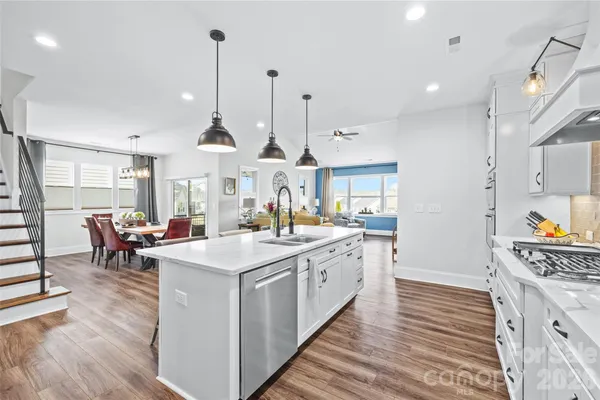 a large kitchen with kitchen island a large counter space a sink stainless steel appliances and cabinets