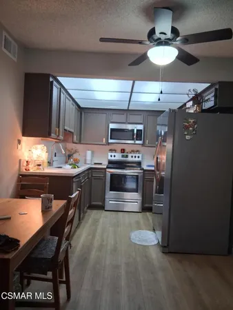 a kitchen with kitchen island stainless steel appliances a stove refrigerator and microwave