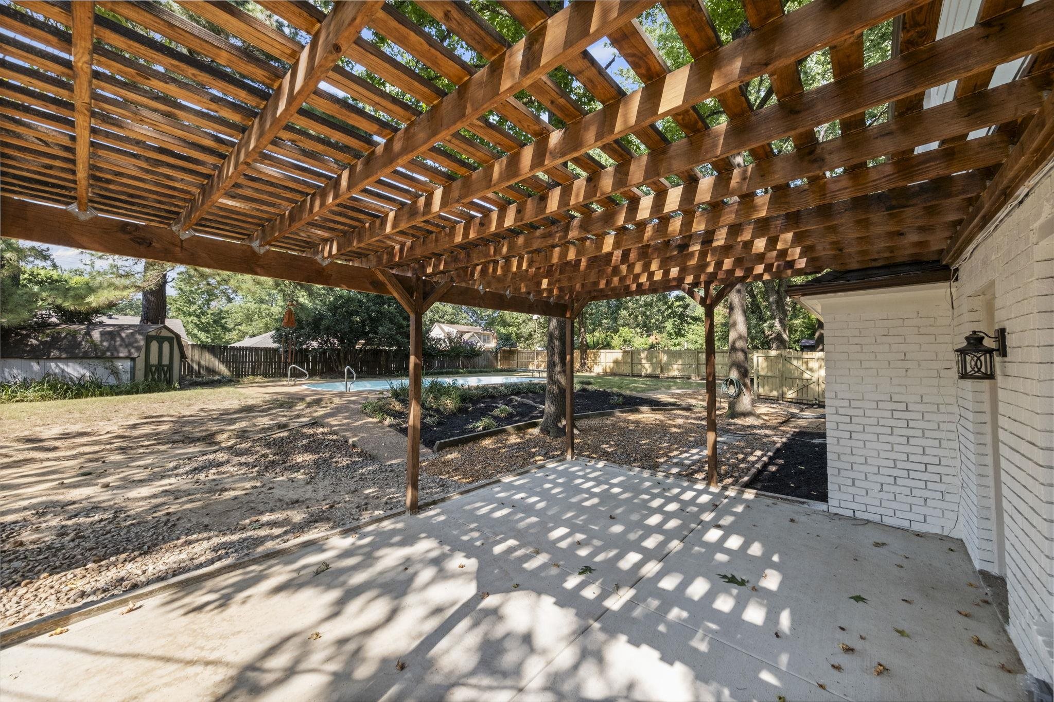 Fenced backyard featuring a storage unit, a patio, and a Freshly stained pergola