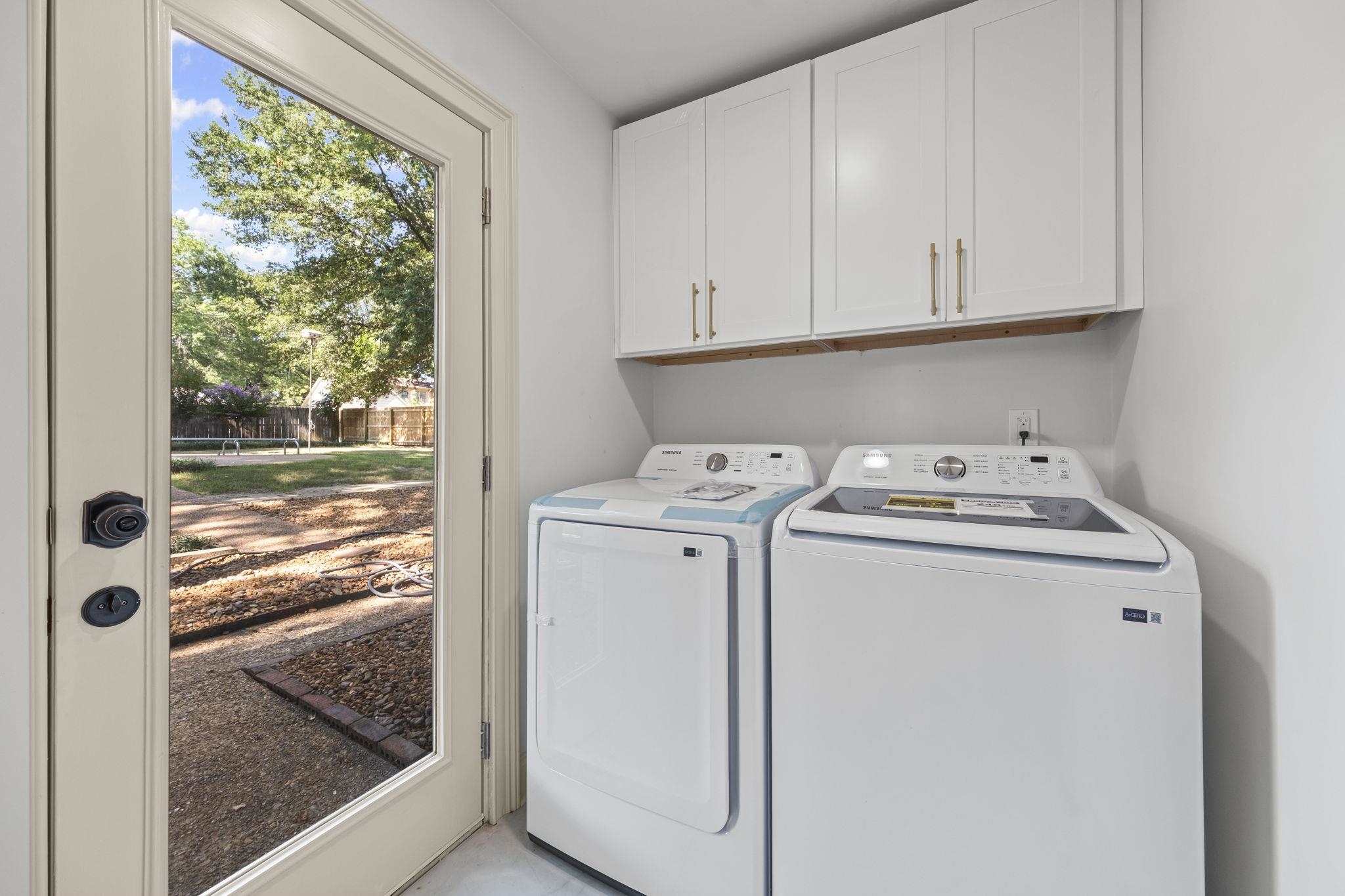 7086 McVay Road Germantown, TN 38138 - Photo 11 of 40 Laundry room with cabinet space and washing machine and dryer. Door to back yard
