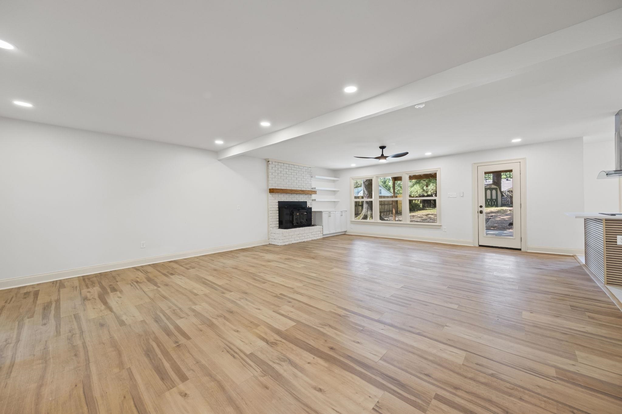 7086 McVay Road Germantown, TN 38138 - Photo 12 of 40 an empty room with wooden floor kitchen view and windows