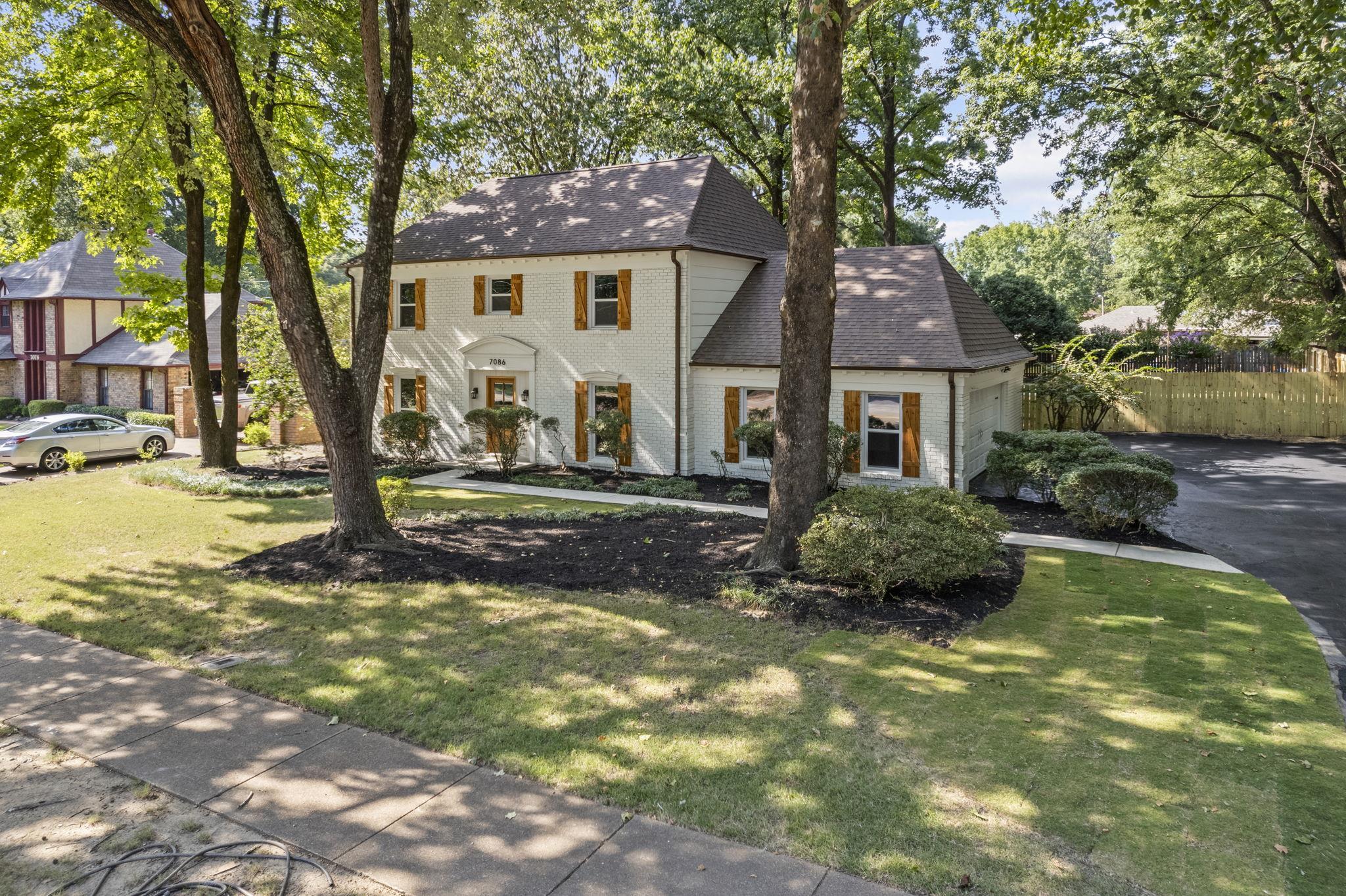 7086 McVay Road Germantown, TN 38138 - Photo 24 of 40 View of front of property with brick siding, a front yard, a shingled roof, a garage, and driveway