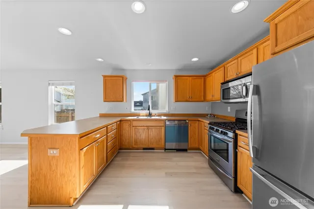 a kitchen with stainless steel appliances granite countertop a stove a sink and a refrigerator