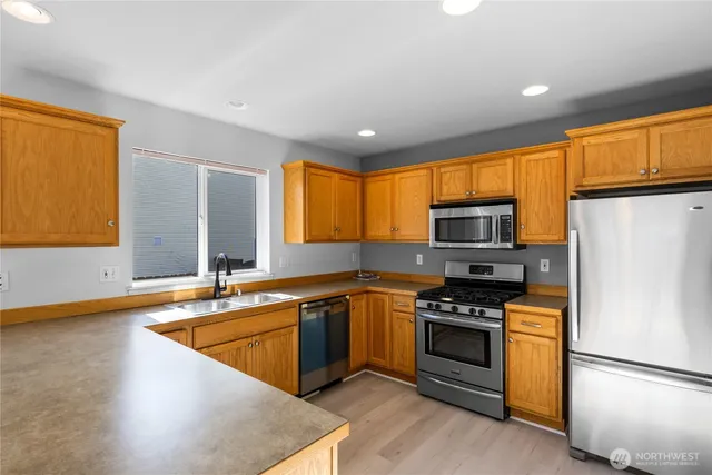 a kitchen with stainless steel appliances granite countertop a stove a sink and a refrigerator