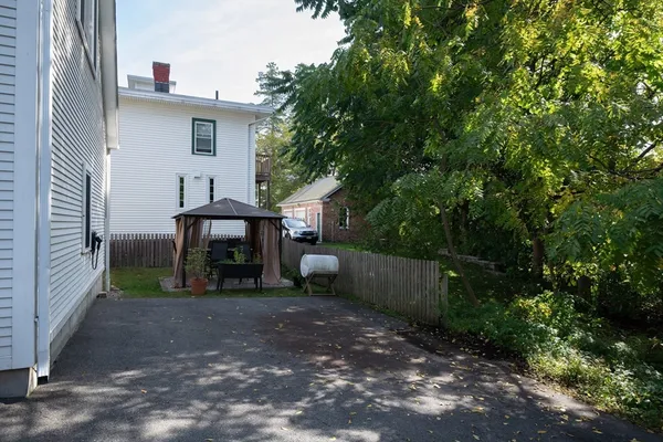 a view of a house with a yard and tree