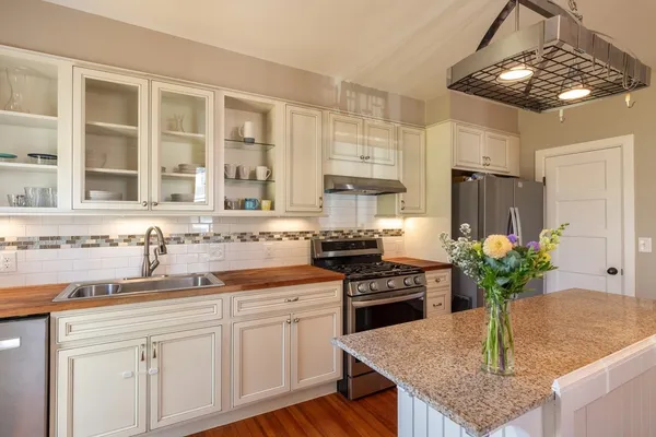 a kitchen with stainless steel appliances granite countertop a sink a stove and a refrigerator