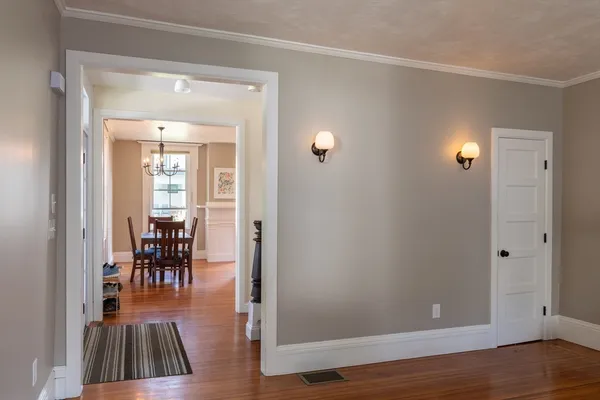 wooden floor in a livingroom and a dining room view with furniture