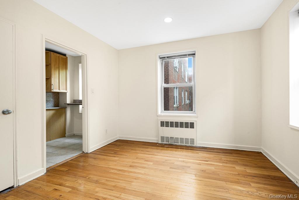 72-10 112th Street, Unit 5B Queens, NY 11375 - Photo 16 of 27 a view of an empty room with wooden floor and a window