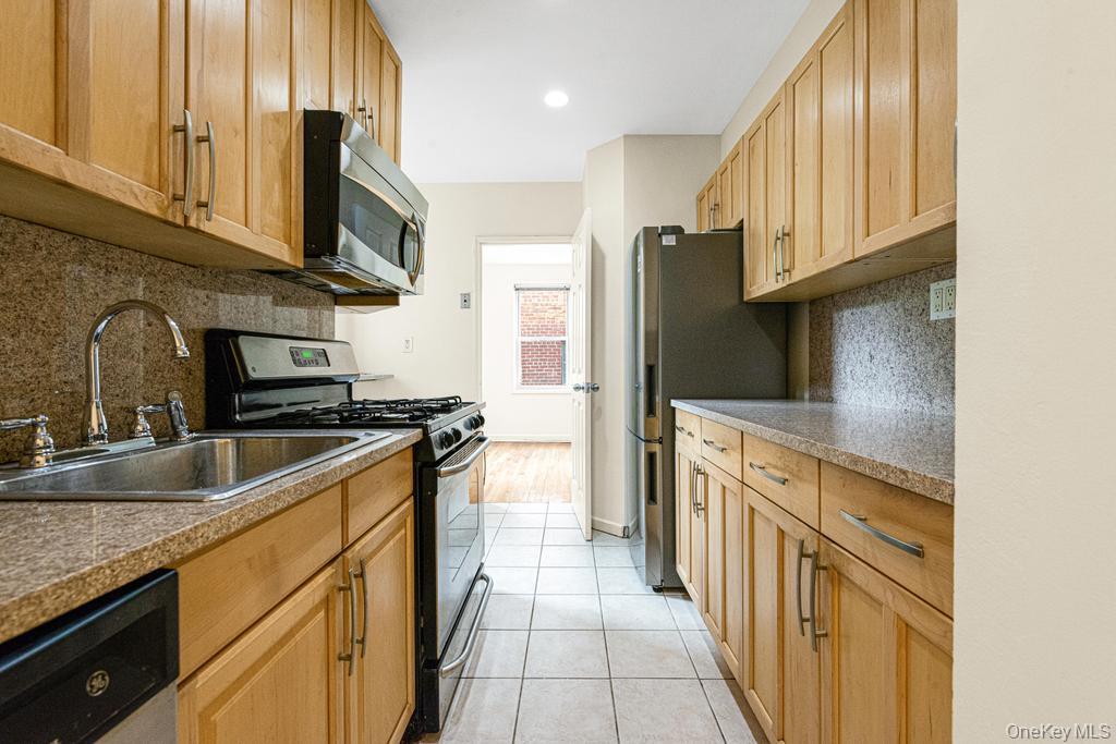 72-10 112th Street, Unit 5B Queens, NY 11375 - Photo 18 of 27 a kitchen with stainless steel appliances granite countertop a refrigerator a stove and a sink